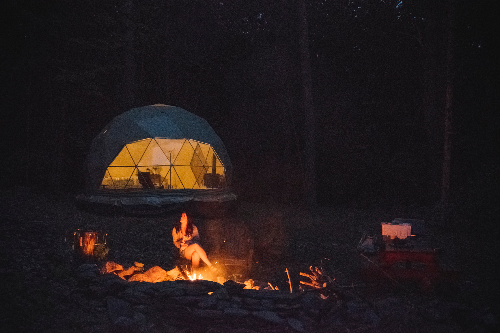 People gathered around fire near dome